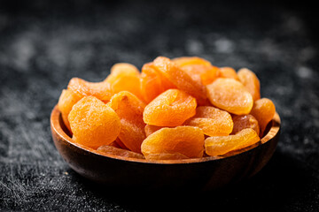 Delicious dried apricots in a wooden plate. 