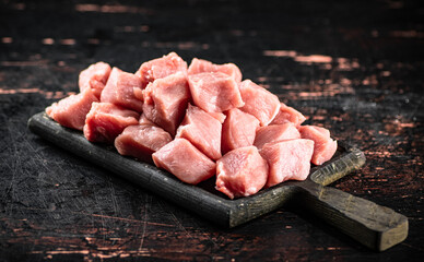 Pieces of raw pork on a cutting board on the table. 