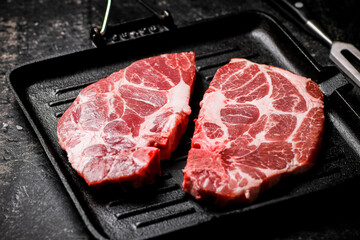 Raw pork steak on a grill pan. 