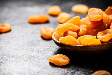 Delicious dried apricots in a wooden plate. 