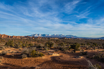 Rock formations with distant snow-covered mountains in the distance in Arches National Park.