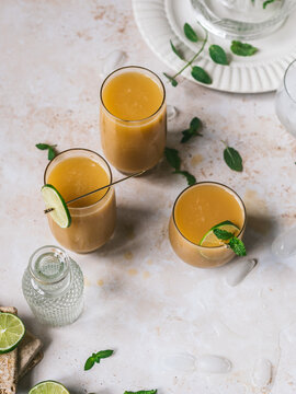 orange cocktails with mint and lime on marble surface