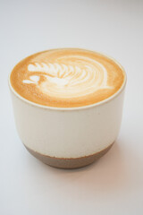 a cup of late coffee with flower shape design on top at cafe 