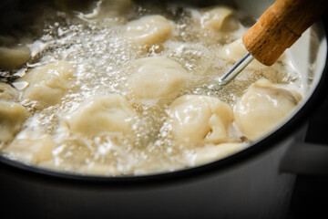 Dumplings are boiled in a saucepan in boiling water. 