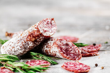 Pieces of salami sausage with sprigs of rosemary. 