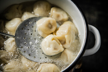 Fototapeta na wymiar Dumplings are boiled in boiling water in a saucepan. 
