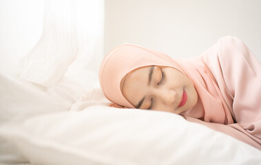 Obraz na płótnie Canvas Portrait of the beautiful sleeping Muslim Asian woman in bed. Side view portrait young cute girl sleeping in bedroom with happy and beauty face. Lifestyle concept