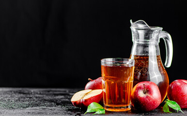 Apple juice in a jug and a glass on the table. 