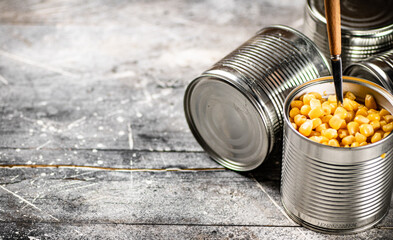 An open can of canned corn with a spoon. 