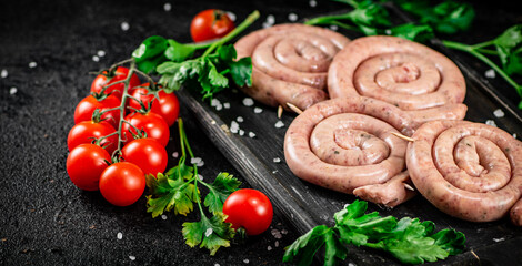 Raw sausages with parsley and tomatoes.