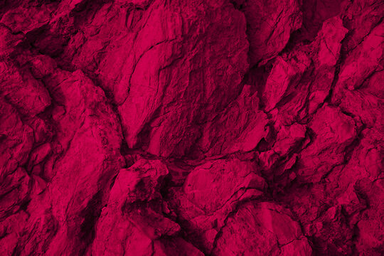 Purple red rock background for design. Dark viva magenta. Color 2023. Toned mountain surface. Close-up. Rough stone texture. Cracked, crumbled, broken. 3d shape.