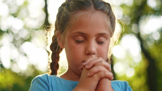 child pray. young gratitude a god religion concept. little girl in nature outdoors praying dreams of happiness to god. praise worship freedom concept lifestyle. kid praying in the forest