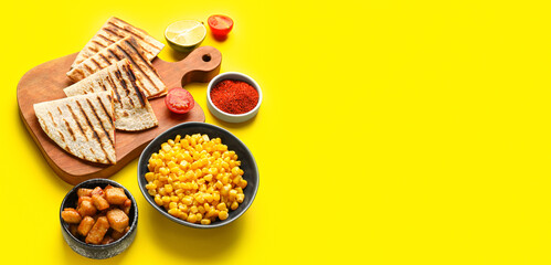 Board with tasty quesadillas and ingredients on yellow background with space for text