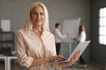 Mature bank manager working with laptop in office