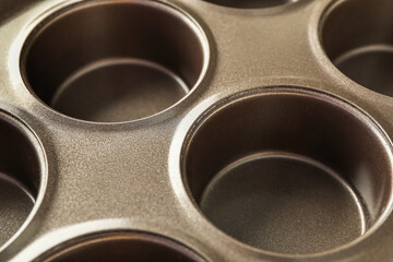 Empty muffin baking tray as background, closeup