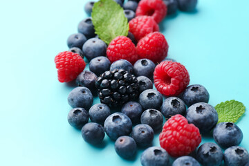 Composition with fresh berries and mint leaves on color background, closeup