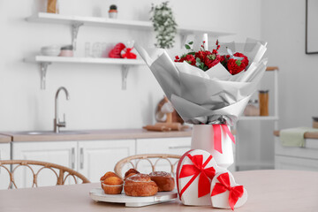 Vase with flowers, pastries and gifts for Valentine's Day on dining table in kitchen