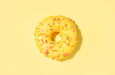 Delicious glazed donut on yellow background