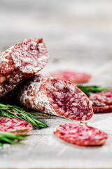 Pieces of salami sausage with sprigs of rosemary. 
