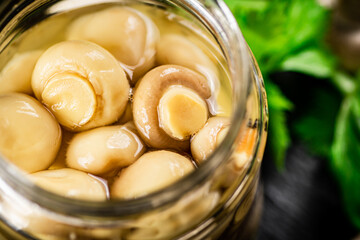 An open jar of homemade pickled mushrooms. 