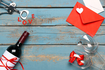 Composition with envelope, bottle of wine, glasses and word LOVE on blue wooden background....