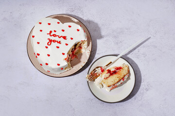 Plates with heart-shaped bento cake on grey background. Valentine's Day celebration