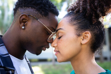 Young African American loving couple tenderly touching foreheads, sharing a romantic, intimate,...