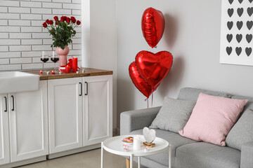 Interior of kitchen decorated for Valentine's Day with counters, sofa and candles
