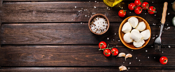Mozzarella cheese on a plate on a table with tomatoes and spices. 