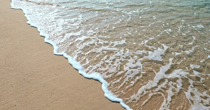 Rolling waves crashed against the sand on the shore. Beautiful seaside scenery in Sanya, Hainan Island, China.