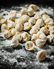 Raw dumplings on the table with flour.