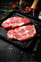 Raw pork steak in a frying pan. 