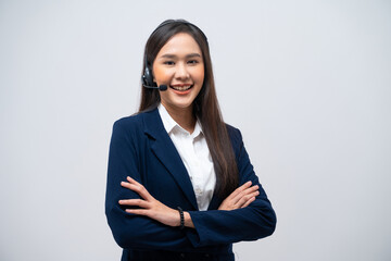 Beautiful Asian call center operator wearing a headset and microphone standing with her arms...