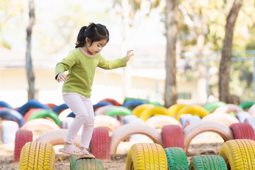 Cute asian girl smile play on school or kindergarten yard or playground. Healthy summer activity...