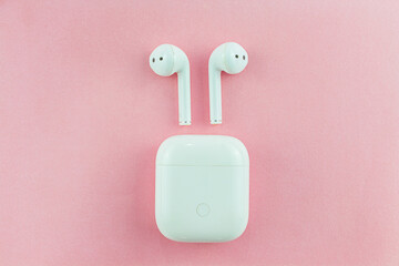 Wireless headphones or Bluetooth headphones on a pink background.