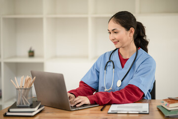 Female doctor sitting at work looking at the history of patients in the clinic or in the hospital