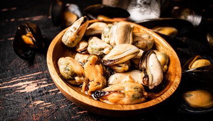 Pickled mussels in a wooden plate on the table. 