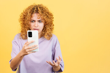 Worried woman with curly hair using a mobile