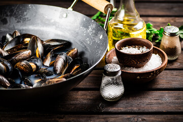 Mussels in a saucepan with parsley and spices. 