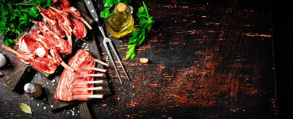 Raw rack of lamb with parsley on a cutting board. 