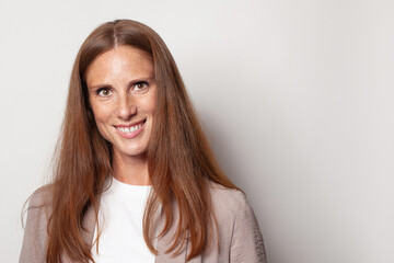 Obraz premium Cheerful woman face. Cute mid adult model with long healthy brown hair smiling