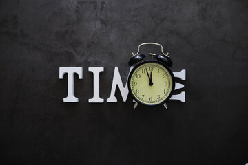 Big alarm clock. The clock is on the table. The inscription "time". Time for rest and travel.