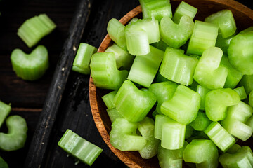 Sliced fresh celery. On a dark wooden background.