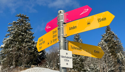 Hiking markings and orientation signs with signposts for navigating in the idyllic winter ambience over the Lake Walen or Lake Walenstadt (Walensee) and in the Swiss Alps, Amden - Switzerland (Schweiz