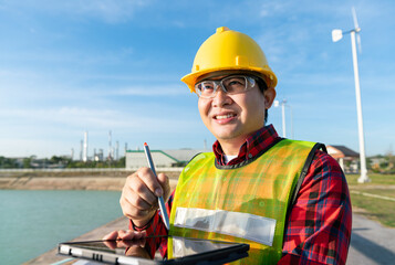 engineer wear safety helmet uniform work with drawing 3D detail in tablet technology with oil refinery, petrochemical, petroleum chemical plastic industrial business in background