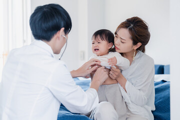 Fototapeta premium 家を訪問したドクターに診てもらう赤ちゃん