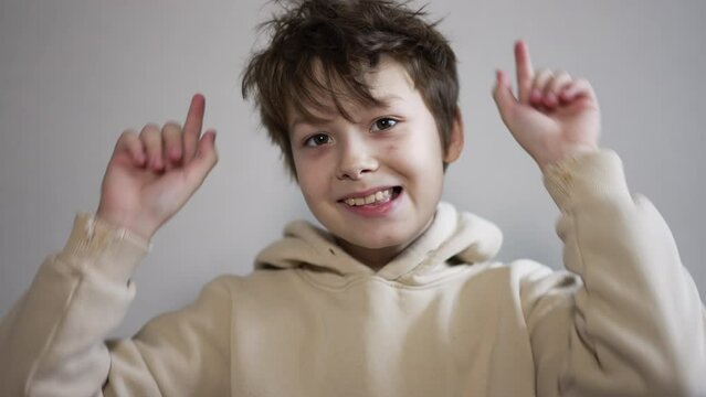 Funny teenager having fun, making faces, fooling around in front of camera. Boy showing tongue. Close up.