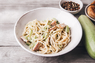 Pasta with zucchini. Homemade spaghetti with vegetables and sausage in a creamy sauce. Italian cuisine.