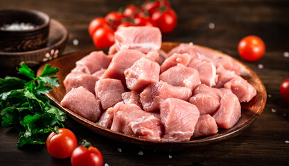 Raw pork sliced on a plate with tomatoes. 