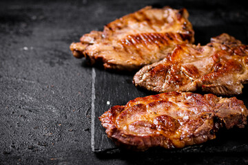 Delicious grilled pork steak on a stone board. 